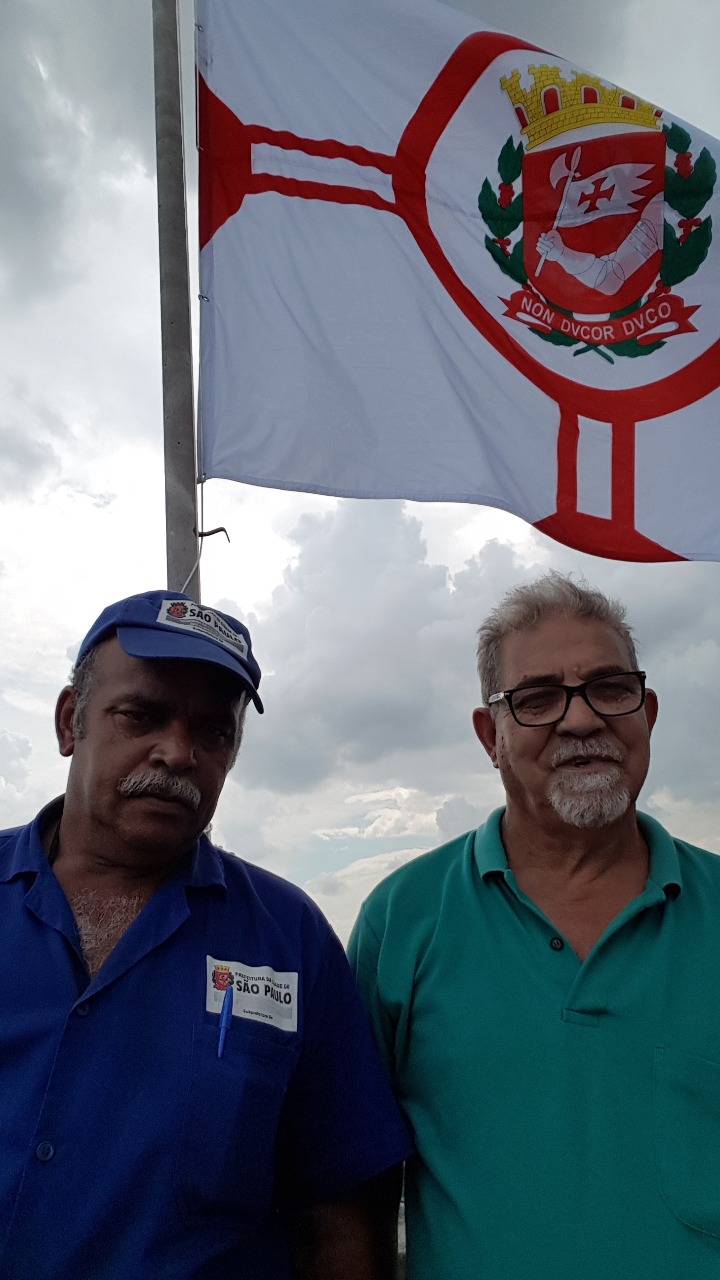 Funcionários orgulhosos por hastearem a bandeira da cidade 